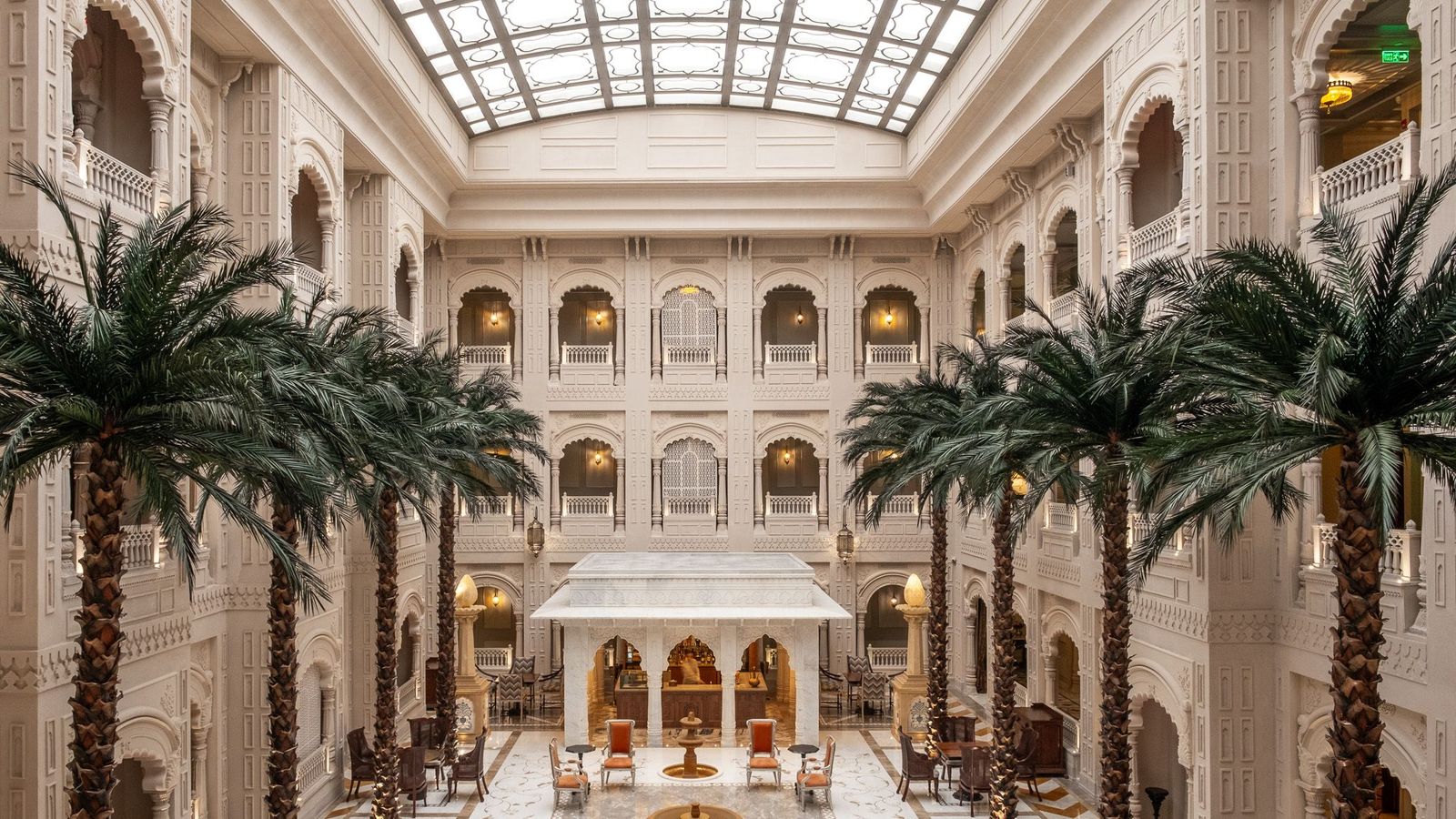 Heritage hotel courtyard with palms under a glass roof